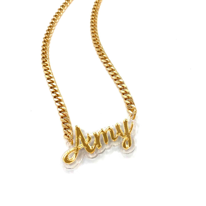 haus of dizzy custom name necklace. clear background with gold mirror text that reads kitty on gold chain