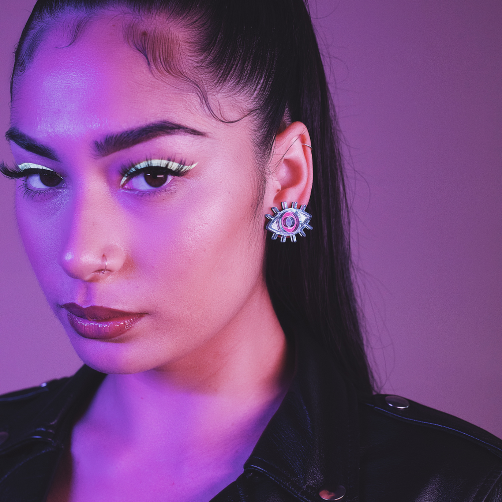 model wearing haus of dizzy eye see you studs in navy, pink and silver mirror